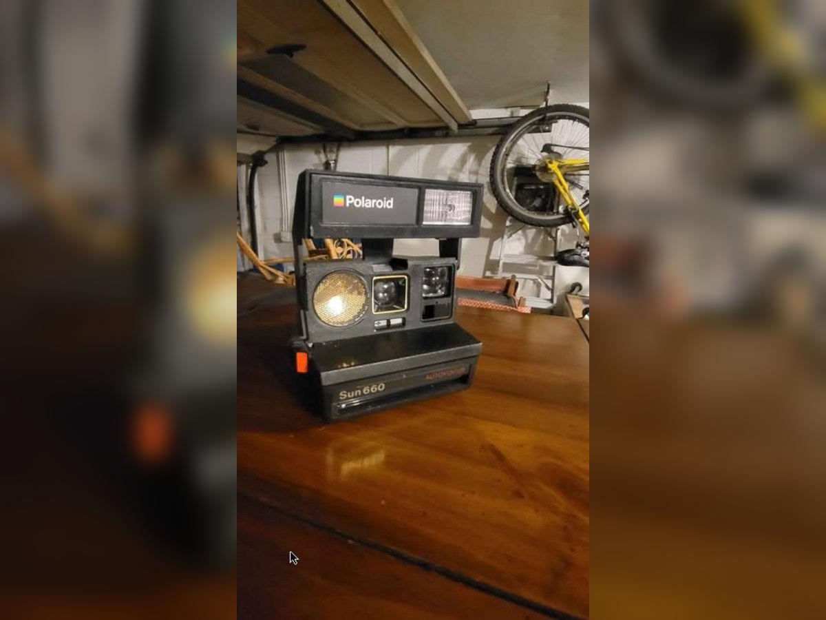 Polaroid Sun 660 AutoFocus instant camera on a wooden table